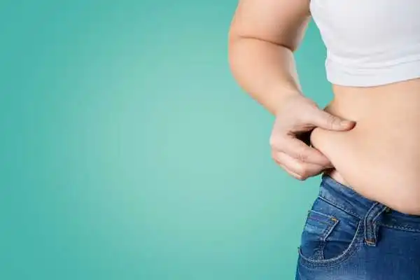 Image of woman pinching her love handles to show weight gain Huntingdon